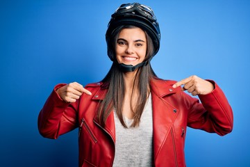 Young beautiful brunette motorcycliste woman wearing motorcycle helmet and jacket looking confident...
