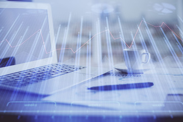 Forex graph hologram on table with computer background. Double exposure. Concept of financial markets.