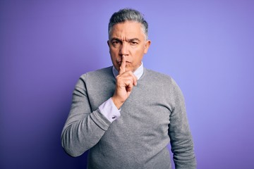 Middle age handsome grey-haired man wearing elegant sweater over purple background asking to be quiet with finger on lips. Silence and secret concept.