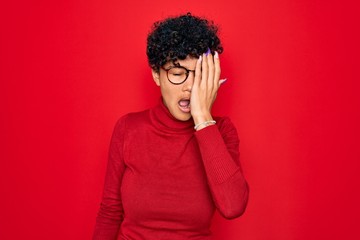 Fototapeta na wymiar Young beautiful african american afro woman wearing turtleneck sweater and glasses Yawning tired covering half face, eye and mouth with hand. Face hurts in pain.