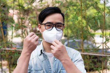 Asian men adjust to wear medical masks on the streets of the city