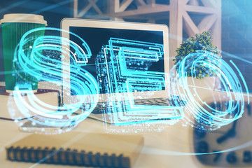 Double exposure of table with computer and seo drawing hologram. Search optimization concept.