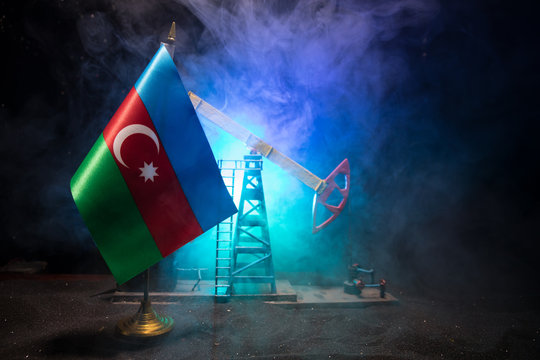 Business dialogue, oil agreement concept: National flags with Oil pump and oil refining factory at night with fog and backlight. Energy industrial concept.