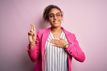 Beautiful african american businesswoman wearing jacket and glasses over pink background smiling...