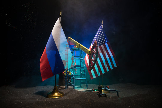 Business dialogue, oil agreement concept: National flags with Oil pump and oil refining factory at night with fog and backlight. Energy industrial concept. - Powered by Adobe