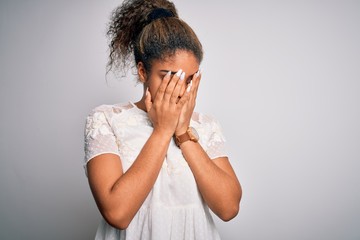 Young beautiful african american girl wearing casual t-shirt standing over white background with sad expression covering face with hands while crying. Depression concept.