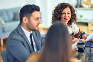 Group of business workers working together. Sitting on desk using laptop reading documents at the office