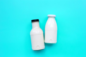 Milk bottle on blue green background.