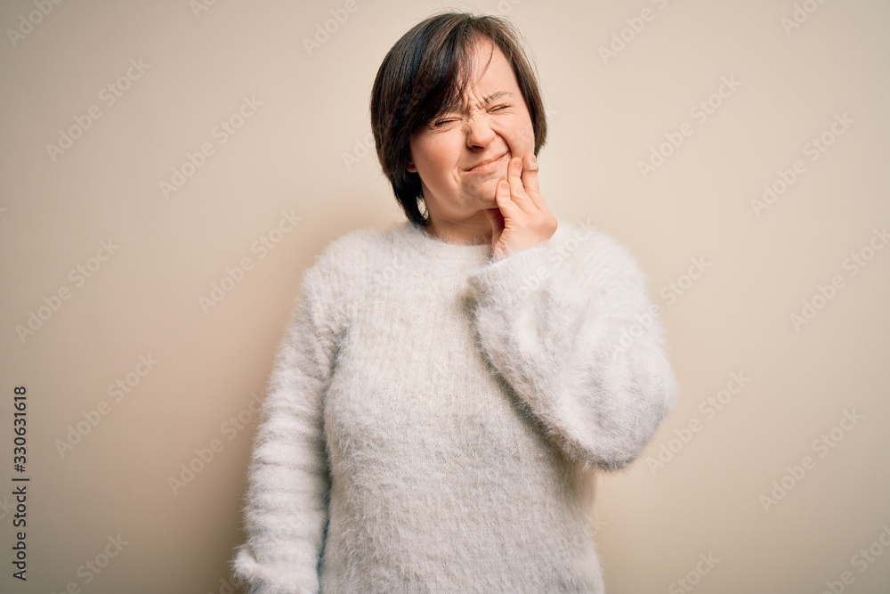 Sticker young down syndrome woman standing over isolated background touching mouth with hand with painful ex