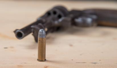 Obraz na płótnie Canvas 9mm ammo with an old revolver in the background