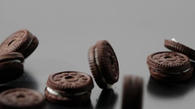 Close-up of Chocolate cookies and cream falling in slow motion on dark background