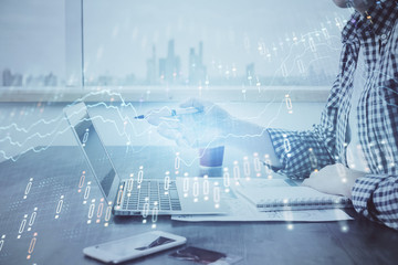 Double exposure of stock market chart with man working on computer on background. Concept of financial analysis.
