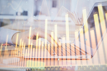 Double exposure of stock market graph with man working on laptop on background. Concept of...