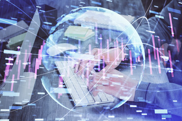 Stock graph with businessman typing on computer in office on background. Concept of analysis. Double exposure.