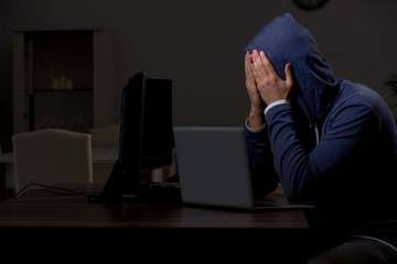 Male hacker hacking security firewall late in office