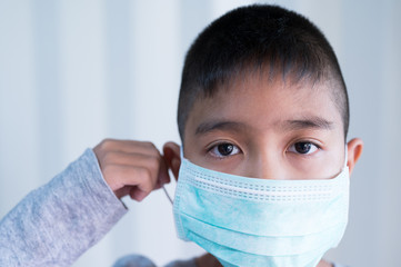 Portrait Asian kid wearing medical mask.A boy wearing mouth mask against air smog pollution. Concept of corona virus quarantine or covid-19.Protection against virus and infection control concept.