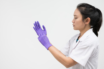 Woman doctor putting blue latex medical gloves on white background.Surgeon wearing gloves before surgery at operating room.Risk and infection control concept.