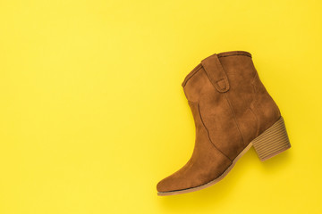 Fashionable women's suede Shoe on a yellow background.