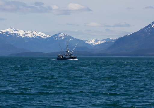 Salmon fishing boat in Southeast Alaska with mountains