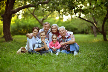Portrait of happy smiling family relaxing in park