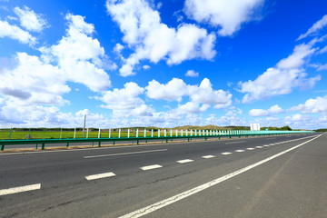 Empty highway, blue sky and white clouds landscape