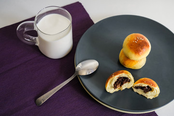 Breakfast red bean bread and a glass of milk on the white table