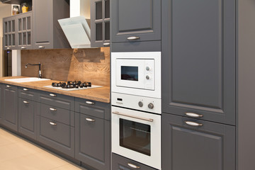 Interior of modern kitchen equipment and grey cabinets