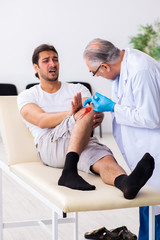 Obraz premium Leg injured man visiting old doctor in first aid concept