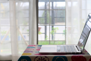 Inside home with portable computer laptop put on small table for work on home, close-up and selective focus