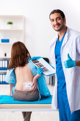 Injured young woman visiting young male doctor