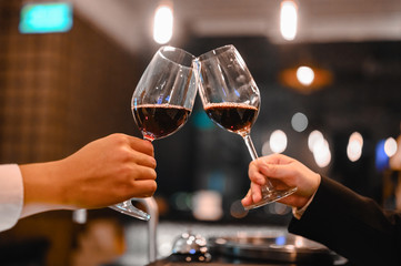 Two bartender enjoying of Cheers glass of wine for wine tasting event in a restaurant  at sunset. bartender, tasting, Dinner, Wine, beverage, dinner concept.