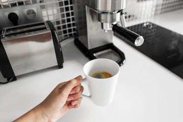 First-person view of a girl preparing delicious aromatic coffee in a coffee machine. A simple way to make coffee