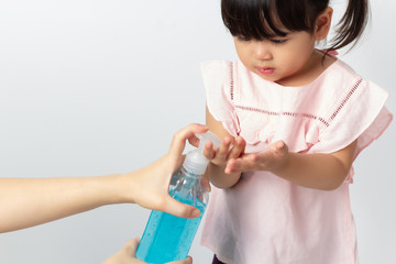 Asian Mom using alcohol antiseptic gel for cleaning baby hands to prevent against infection of Covid-19 outbreak