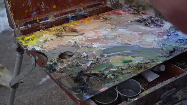 The Artist's Oil Palette on paintboxe. Mixing oil paint for painting