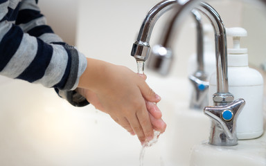 Closeup, a boy wash hand, between fingers, nails and back of his hand with soap thoroughly and properly to disinfect virus and protect from pandemic of covid-19, virus outbreak and epidemic of disease