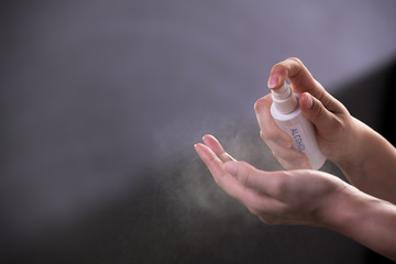 Hands spraying alcohol hand sanitizer for disinfection hygiene and protection against COVID-19 and other diseases