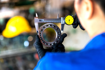 Femal technician measuring ball bearing by vernier caliper tools on a hand. Close-up.