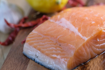 Fresh raw salmon fillets on wooden background.