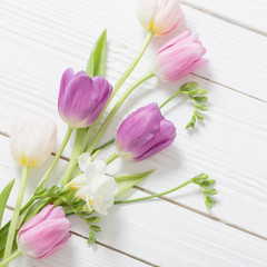 Obraz na płótnie Canvas spring flowers on white wooden background
