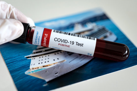 Testing for presence of coronavirus. Tube containing a blood sample that has tested positive for COVID-19. Image of cruise ship in the background.