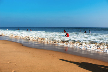 Golden Sea beach visitors in the sea white foam wave blue sky be