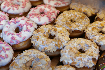 Many various of chocolate sugar donuts display for sale .