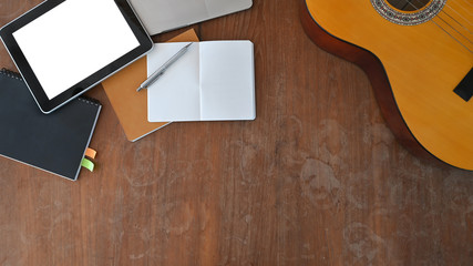 Top view image of Musician workplace. Acoustic guitar, Notes, Computer tablet with white blank...