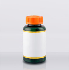 green plastic bottle medicine container or vitamin capsules with white and gold label and orange lid with safety lock on white background for silhouetting