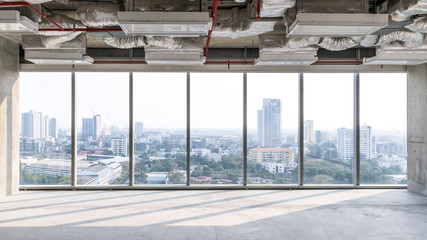 High rise office under construction with open ceiling to see structure and system work, glass...