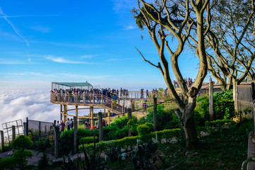 Silhouette of travelers enjoying the scenic view from a huge walkway on the hill at Nandi Hills, Bengaluru, Karnataka