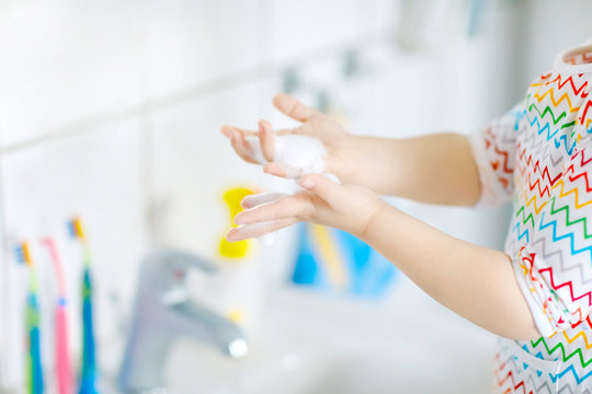 Closeup Of Little Toddler Girl Washing Hands With Soap And Water In Bathroom. Close Up Child Learning Cleaning Body Parts. Hygiene Routine Action During Viral Desease. Kid At Home Or Nursery.