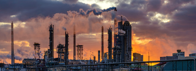 chemical plant at sunrise. Smoke and pollution illuminated by the rays of the rising sun