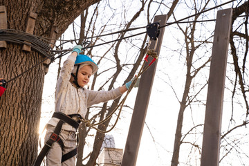 child girl climb in rope Park in the spring