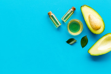 Avocado oil - ingredient for cosmetics - on blue background top-down frame copy space